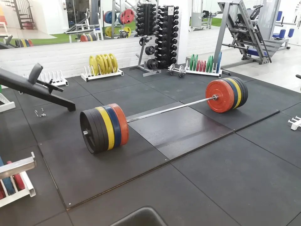 Deadlift area: a loaded Olympic barbell with colourful weight plates