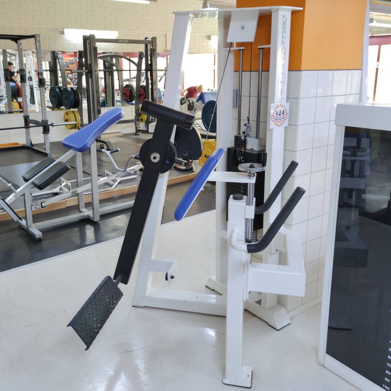 Standing glute kickback machine with a chest support, handles and a footplate