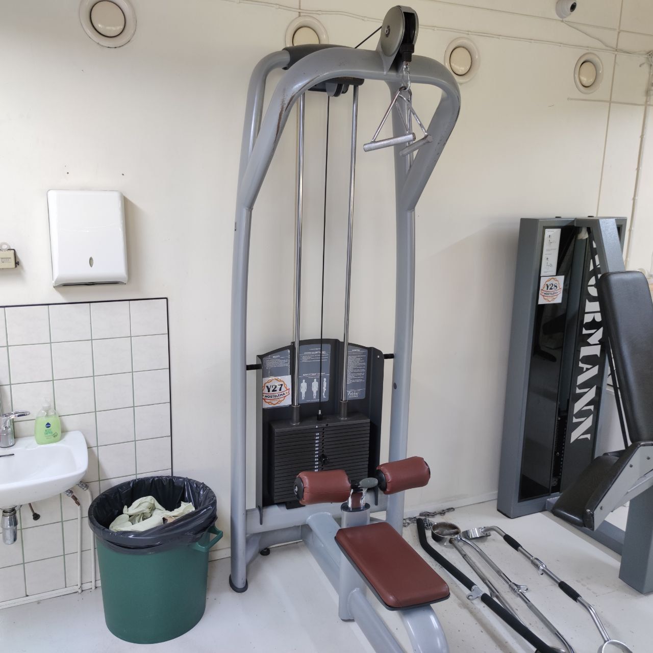 Lat pulldown with a seat, brown thigh pads and a triangle handle