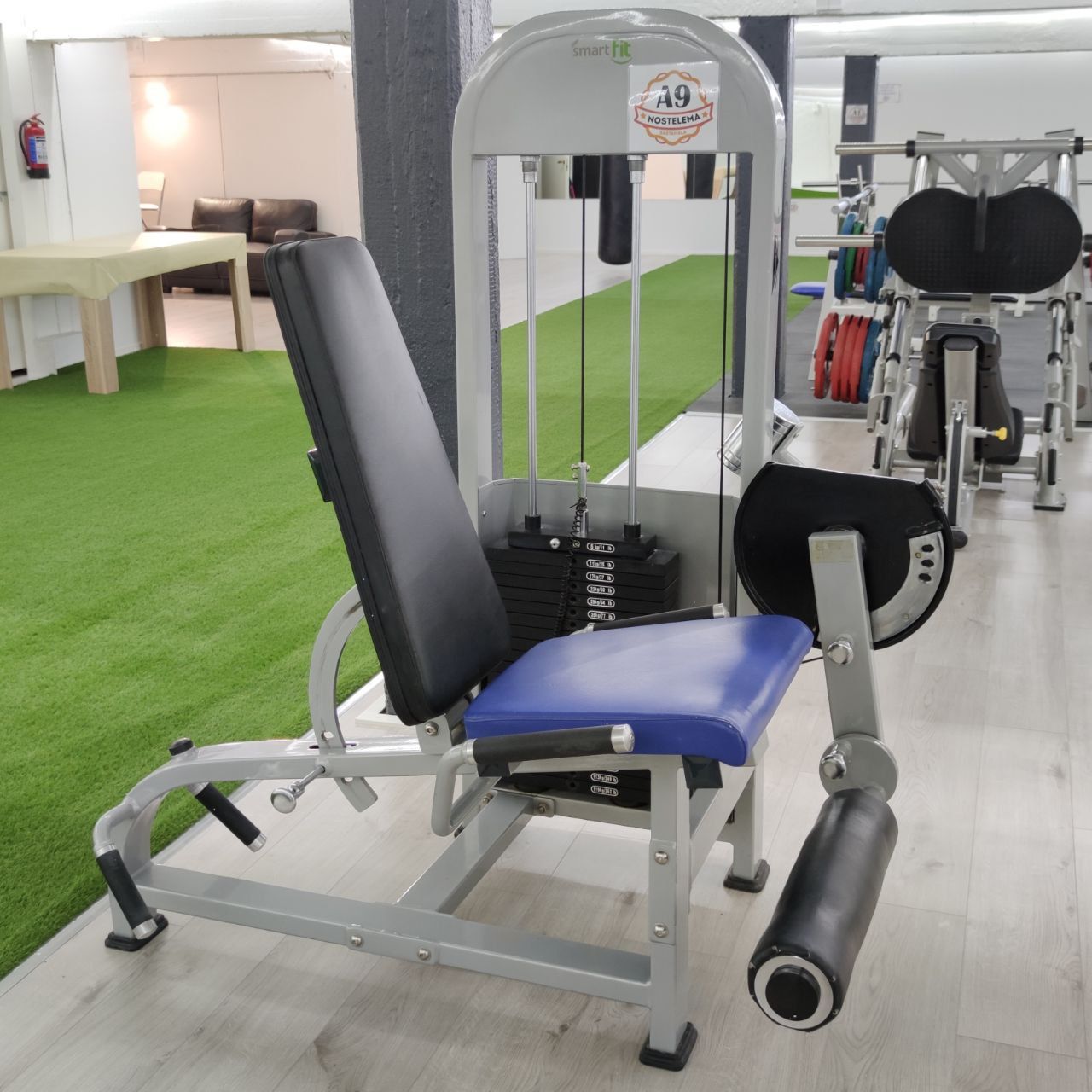 Combination machine set up for leg extension, backrest upright