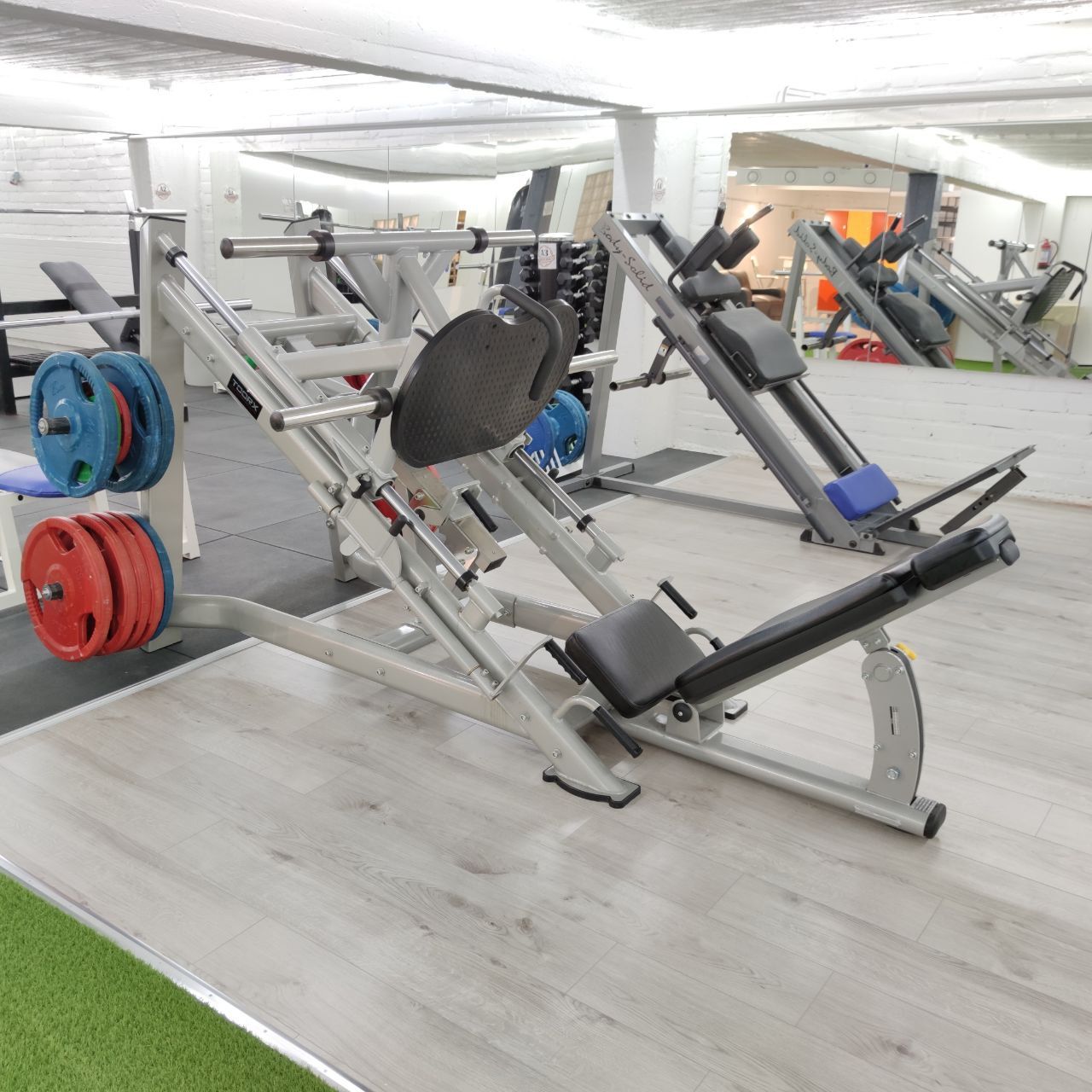 Plate-loaded leg press, with a second similar machine behind it