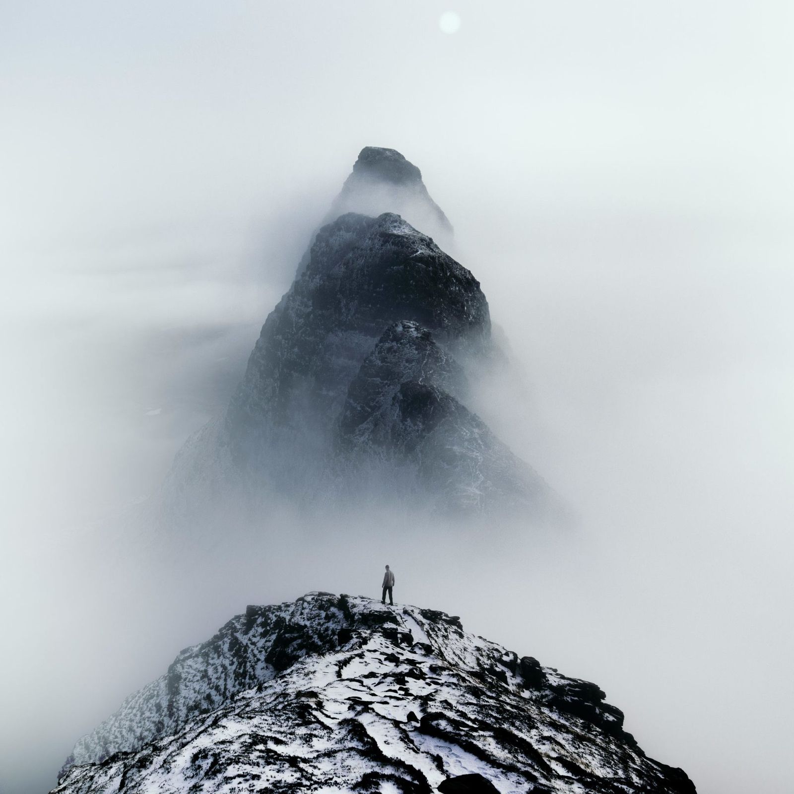Person on a snowy mountain top in the fog (stock photo)